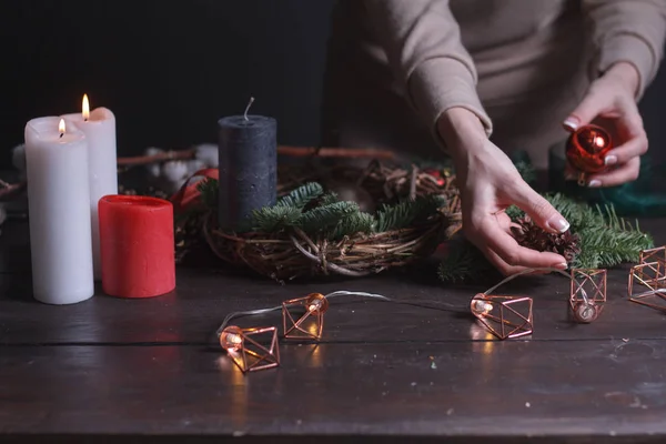 Gros plan d'une fleuriste faisant une couronne de Noël de branches de sapin, mise au point sélective — Photo