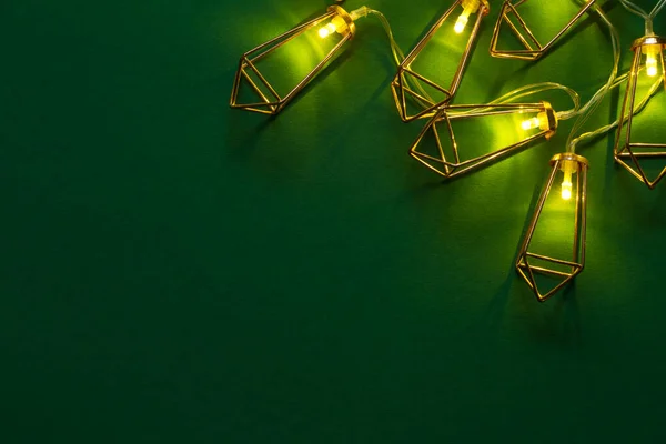 Fondo o concepto navideño, guirnalda luminosa de cobre sobre fondo verde —  Fotos de Stock