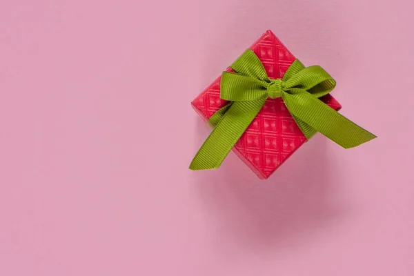 Красный подарок или коробка подарка с зеленой лентой на розовом столе вид сверху. Плоский лежал. День рождения, свадьба или Рождество . — стоковое фото