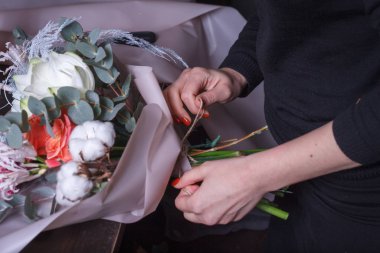 Kadın çiçekçi sipariş için bir buket yapar, kendi çiçek işi konsepti, seçici odaklanma