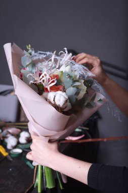 Kadın çiçekçi sipariş için bir buket yapar, kendi çiçek işi konsepti, seçici odaklanma