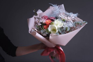 Kadın çiçekçi sipariş için bir buket yapar, kendi çiçek işi konsepti, seçici odaklanma