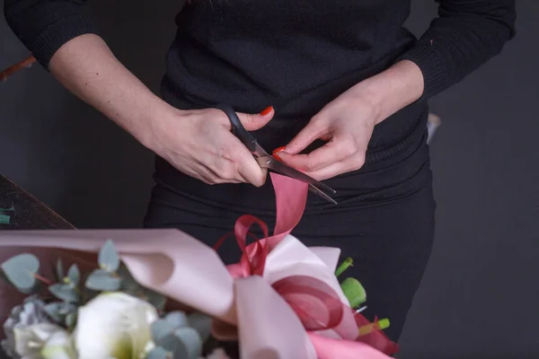 Mujer florista hace un ramo a pedido, concepto de negocio de flores propias, enfoque selectivo — Foto de Stock