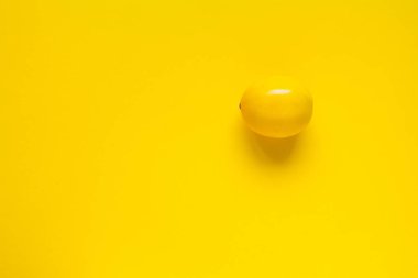 Sarı bir zemin üzerinde olgun sarı limon, minimal arkaplan veya konsept