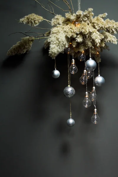 A decorative reed clouds hanging from above with a Christmas decor and a garland of light bulbs, Christmas or New Year concept