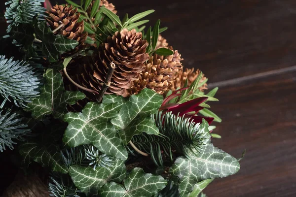 Winter bouquet of Nobil fir twigs, cones, pistachio, leucodendron and ivy, winter gift concept — Stock Photo, Image