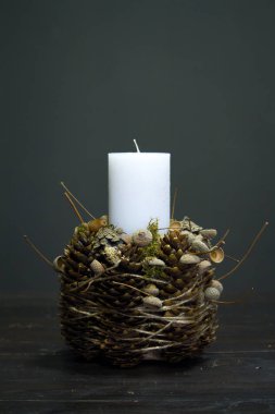 Ahşap bir yüzeyde beyaz mum bulunan kış dekorunun yakın çekimi, seçici bir odak