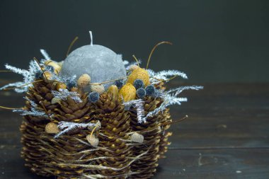 Ahşap bir yüzey üzerinde gri mum bulunan kış dekorunun yakın çekimi, seçici bir odak noktası