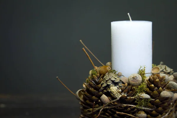 Close-up of winter decor with white candle on a wooden surface, selective focus — Stock Photo, Image