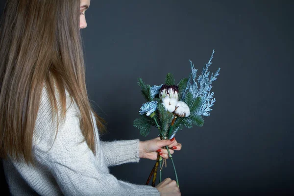 Woman florist makes a bouquet to order, concept of own flower business, selective focus