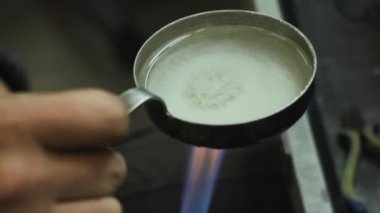 Gümüş bir bilezik üretme süreci, usta kuyumcu kimyasal bir çözüm hazırlar, seçici bir odak.