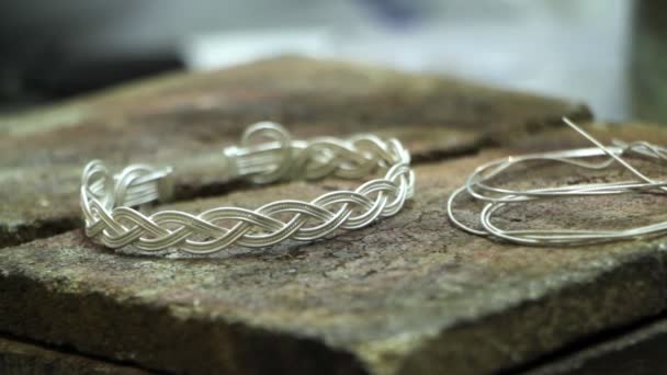 Gros plan d'un bracelet en argent fini sur le bureau d'un bijoutier, production manuelle de bijoux en argent, mise au point sélective 