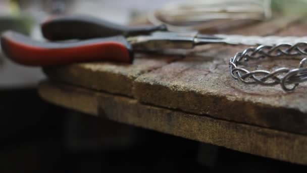 Gros plan d'un bracelet en argent fini sur le bureau d'un bijoutier, production manuelle de bijoux en argent, mise au point sélective 