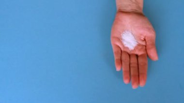 Evde kahvaltı sırasında akıllı telefon kullanan bir kadın kahve fincanı hazırlarken, seçici bir şekilde odaklanır.