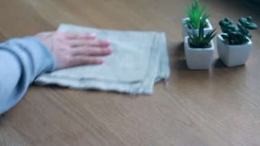 Evde kahvaltı sırasında akıllı telefon kullanan bir kadın kahve fincanı hazırlarken, seçici bir şekilde odaklanır.