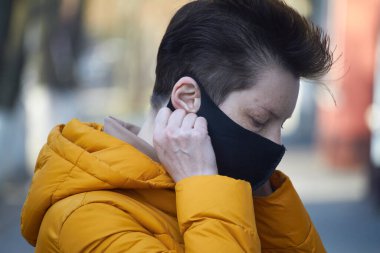 Orta yaşlı siyah maskeli Avrupalı kadın, Coronavirus COVID-19 salgını sırasında maske takan kadın, salgın sırasında koruyucu takan hasta kadın..