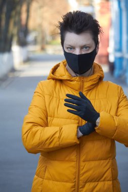 Orta yaşlı siyah maskeli Avrupalı kadın, Coronavirus COVID-19 salgını sırasında maske takan kadın, salgın sırasında koruyucu takan hasta kadın..
