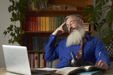 Mesafe öğrenme kavramı. Öğretmen bilgisayar ekranına dikkatlice bakıyor ve öğrenciyi online derste dinliyor, seçici odaklanma.