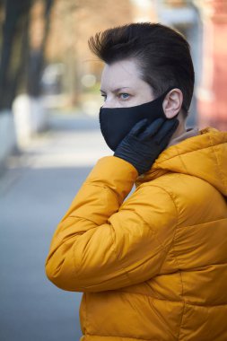Orta yaşlı siyah maskeli Avrupalı kadın, Coronavirus COVID-19 salgını sırasında maske takan kadın, salgın sırasında koruyucu takan hasta kadın..