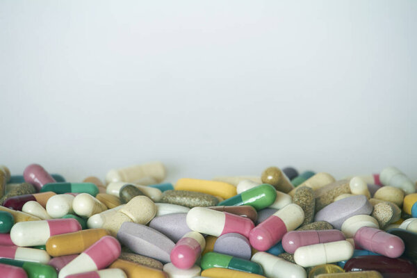 Concept of treatment, options for forms of pharmacological preparations, backdrop of multicolored medicine pills and capsules.