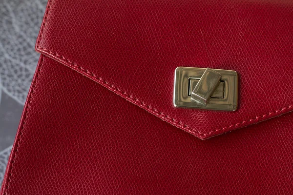 Red leather bag with gold elements on grey background. Free space for logo or advert.