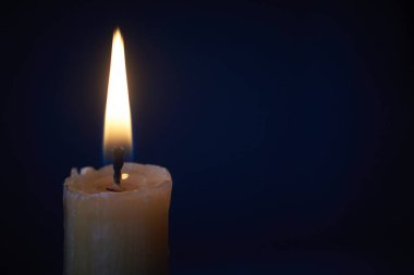 Karanlıkta yanan beyaz mum, siyah arka planda yanan mum, seçici odak