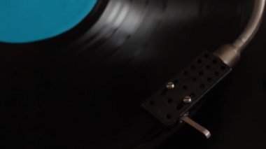 Son derece yakın çekim erkek eli retro plakçalara başlıyor, stili bırakıyor, seçici odaklanıyor.
