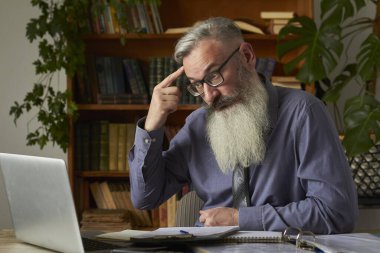 Mesafe öğrenme kavramı. Öğretmen öğretmen dizüstü bilgisayara bakıyor ve video iletişimi hakkında konuşuyordu, seçici odaklanma