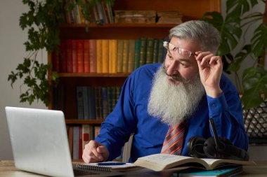 Mesafe öğrenme kavramı. Öğretmen öğretmen dizüstü bilgisayara bakıyor ve video iletişimi hakkında konuşuyordu, seçici odaklanma