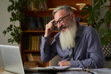 Mesafe öğrenme kavramı. Öğretmen öğretmen dizüstü bilgisayara bakıyor ve video iletişimi hakkında konuşuyordu, seçici odaklanma