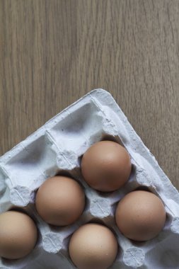 Kahverengi yumurtalar yakın plan, karton tepside tavuk yumurtaları tahta masada, seçici odaklanma