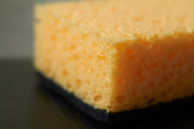 Bulaşıkları yıkamak için soyut arka plan sarı sünger, yakın plan, seçici odaklanma