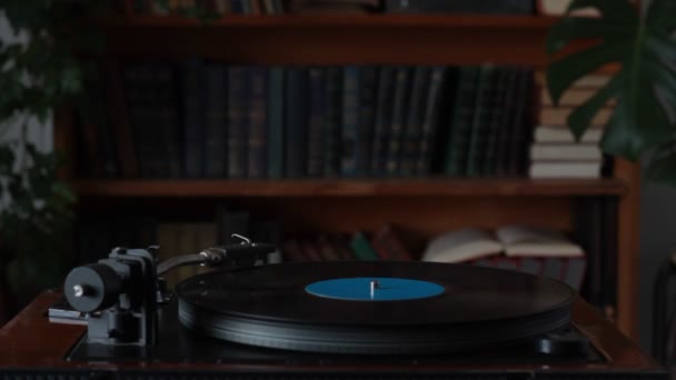 Man in wit shirt zet retro record speler uit, verwijdert de naald uit record, selectieve focus — Stockvideo