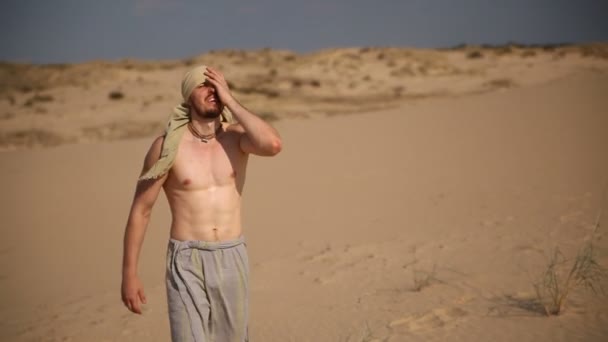 Un hombre camina por el desierto — Vídeo de stock