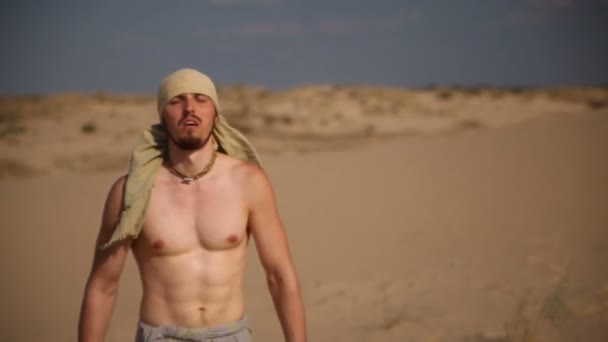 Un hombre camina por el desierto — Vídeo de stock