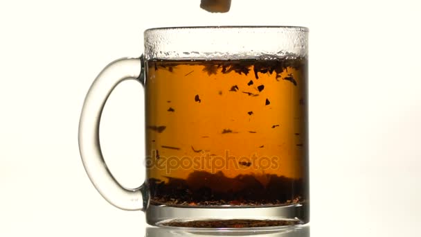 The cup of tea thrown refined sugar — Stock Video