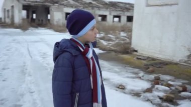 Bir çocuk bir daraltılmış çiftliğinin yakınlarında duruyor
