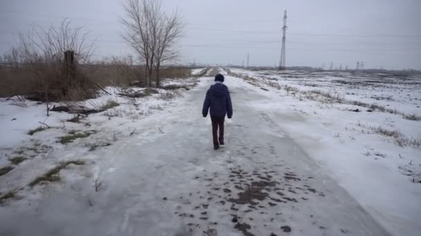 Menino andando na estrada congelada — Vídeo de Stock