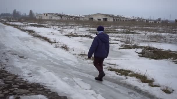 Boy walking on frozen road — Stock Video