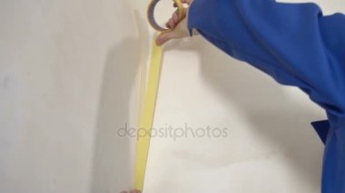 Çalışan yapıştırıcı bant duvardaki