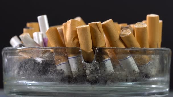 Незавершённые статьи о сигаретах в пепельнице — стоковое видео