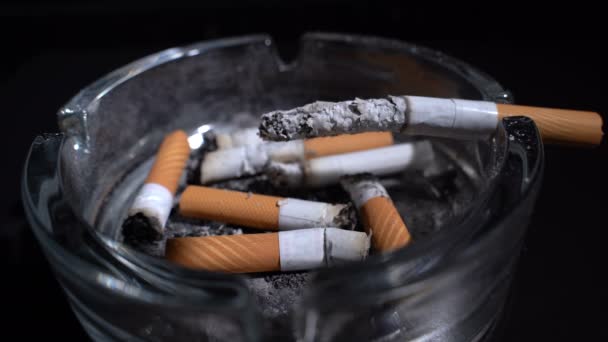 Курит сигарету в пепельнице — стоковое видео