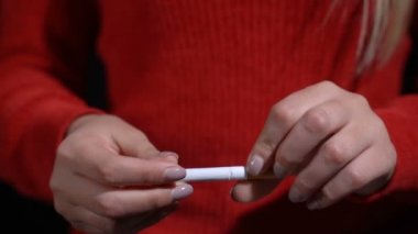 Kız elleriyle sigara kırıyor.