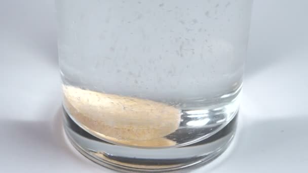 Um comprimido é jogado em um copo — Vídeo de Stock