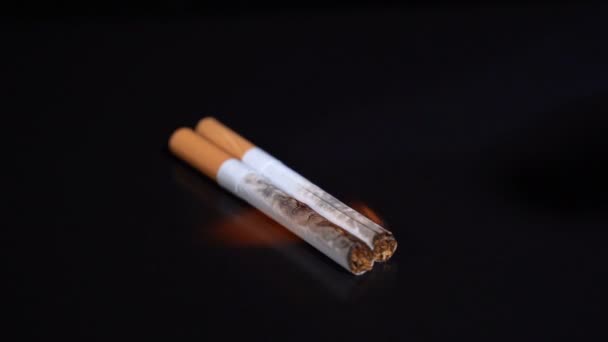 Prende fuego a un cigarrillo sobre un fondo negro — Vídeo de stock