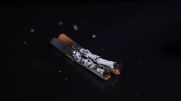 Prende fuego a un cigarrillo sobre un fondo negro — Vídeo de stock