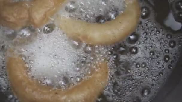 Пончики жарят в растительном масле — стоковое видео