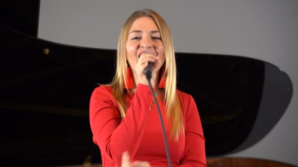 Una chica canta en un micrófono en el escenario — Vídeos de Stock
