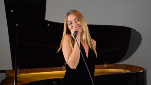 一个女孩在舞台上对着话筒唱歌 — 图库视频影像