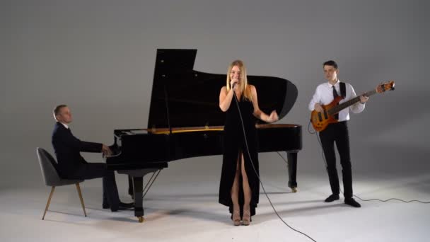 Дівчина співає в тріо музикантів — стокове відео